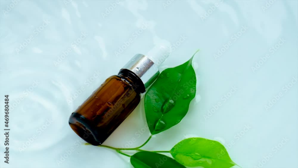 Cosmetics tea tree in a bottle on a water background. Selective focus. Cosmetics tea tree in a bottle on a water background. Selective focus.