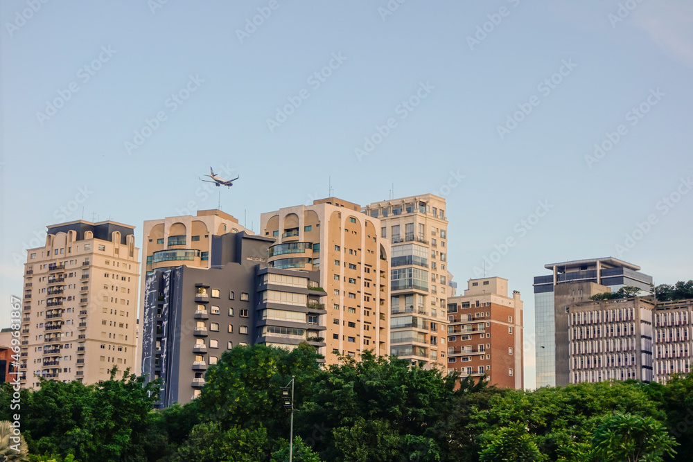 plane flying over modern buildings in the city, skyscrapers