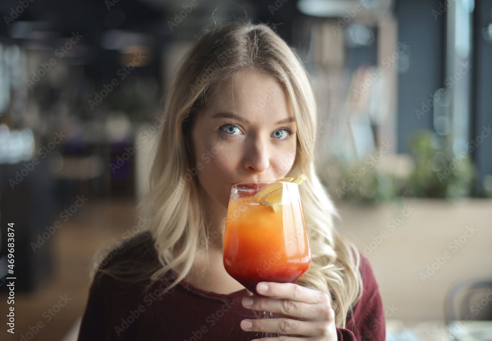 young woman in a bar drinks a cocktail young woman in a bar drinks a cocktail
