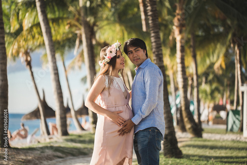Beautiful pregnant girl and man on the beach