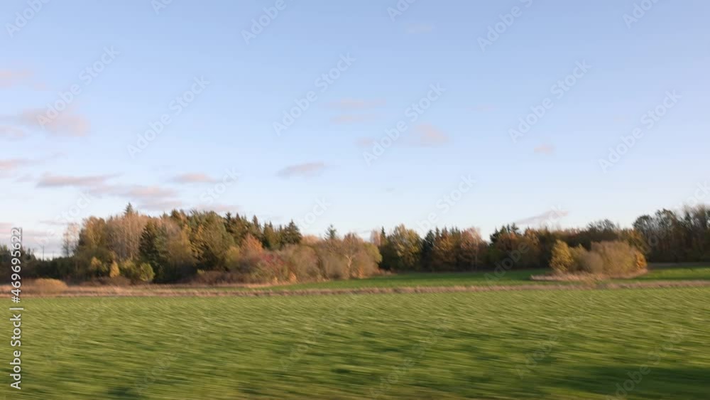 Beautiful autumn day and the view from the car. Gorgeous landscape with fields, forest trees and blue sky with white clouds. Sweden. Beautiful autumn day and the view from the car. Gorgeous landscape with fields, forest trees and blue sky with white clouds. Sweden.