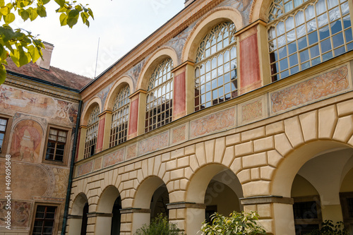 Castolovice, Eastern Bohemia, Czech Republic, 11 September 2021: renaissance castle with tower at sunny day, courtyard with arcades and geometric flower beds, murals and sgraffito plaster on walls photo