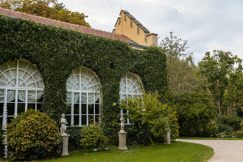 Castolovice, Eastern Bohemia, Czech Republic, 11 September 2021: renaissance castle with winter gardens or greenhouse, buildings braided with evergreen ivy, chateau at sunny day photo