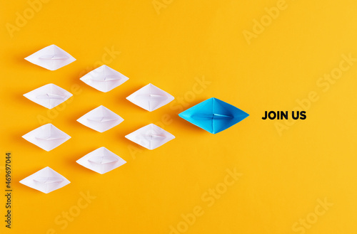 Foto Blue paper boat leads white paper ships with the meaage join us