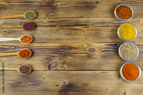 Set of different aromatic spices on wooden table. Top view, copy space