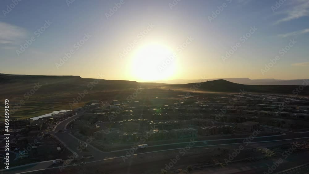 Flight over the city with roads and passing cars in the valley in the mountains at sunset Flight over the city with roads and passing cars in the valley in the mountains at sunset