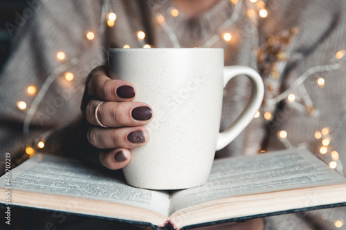 girl having a break with cup of fresh coffee after reading books or studying. manicure