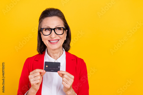 Photo of hr aged brunette lady with card look promo wear spectacles red cardigan isolated on yellow color background