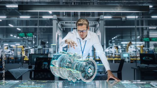 Confident Engineer in White Shirt Working on Jet Engine with Use of Augmented Reality Hologram in an Office at Plane Assembly Plant. Industrial Specialist Working in Technological Development Facility photo