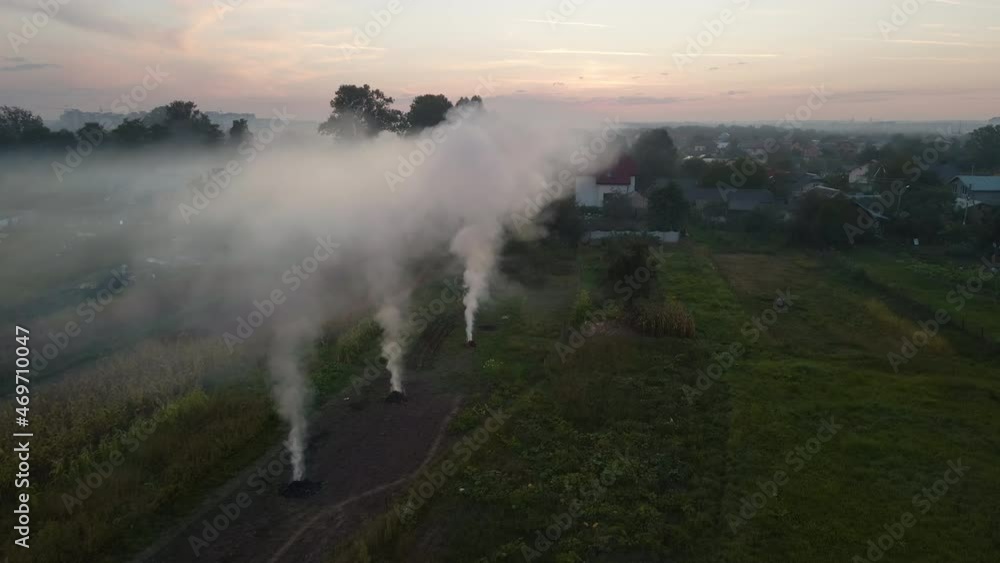 Aerial view of agricultural waste bonfires from dry grass and straw stubble burning with thick smoke polluting air during dry season on farmlands causing global warming and carcinogen fumes. Aerial view of agricultural waste bonfires from dry grass and straw stubble burning with thick smoke polluting air during dry season on farmlands causing global warming and carcinogen fumes.
