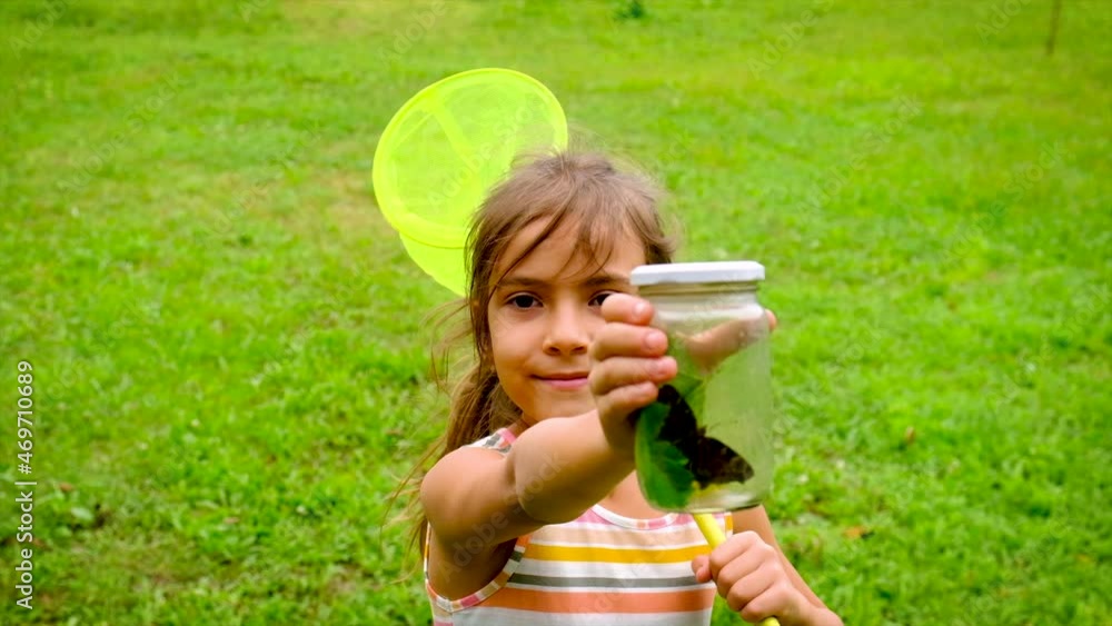 A child girl catches butterflies with a butterfly net. Selective focus. A child girl catches butterflies with a butterfly net. Selective focus.