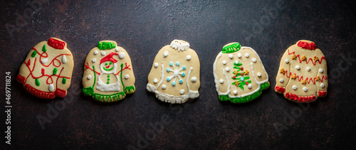 A row of ugly Christmas sweater cookies against a dark background.