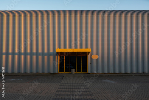 Tinplate and metal architectural wall of the building against the sky with door
