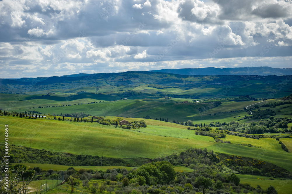 Tuscany, italy, may 2018, panoramic view of a green valley with a lake and olive trees