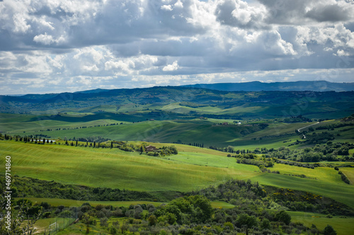 Tuscany, italy, may 2018, panoramic view of a green valley with a lake and olive trees