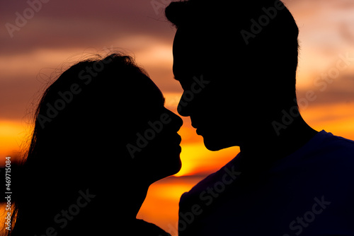 Close up portrait of two young lovers kissing on the sunset
