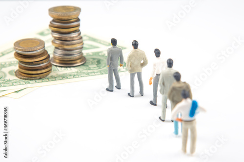 miniature people. different businessman stands near dollar money. investments and earnings for work