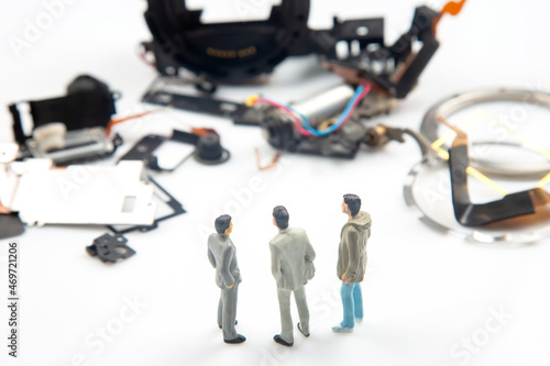 Miniature people. Business men stand near disassembled parts of an electronic device. Business entrepreneur concept