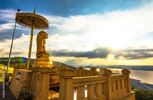 Buddha image in the posture of Naga Prok on Khao Yai Thiang by the upper reservoir at sunset in Nakhon Ratchasima, Thailand. photo