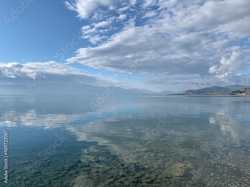 Blue sky and white cloud reflection on the perfect surface of the mountains lake