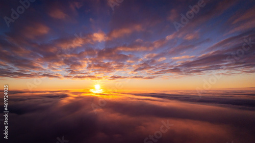 Drone photo of setting sun above clouds in the sky. Dramatic drone photo flying high in the clouds