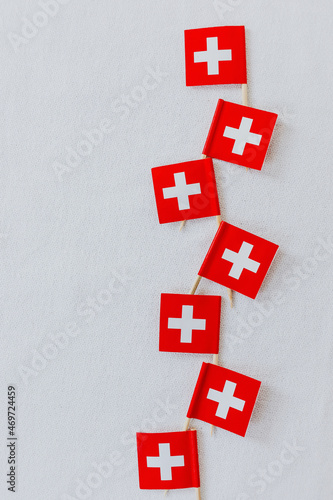 Swiss flags on wooden toothpicks used to decorate the traditional swiss bread baked on Swiss National Day on August 1st. White background, isolated, copy space. photo