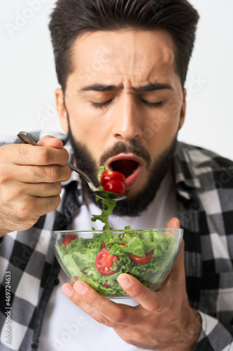 man in plaid shirt eating salad healthy food