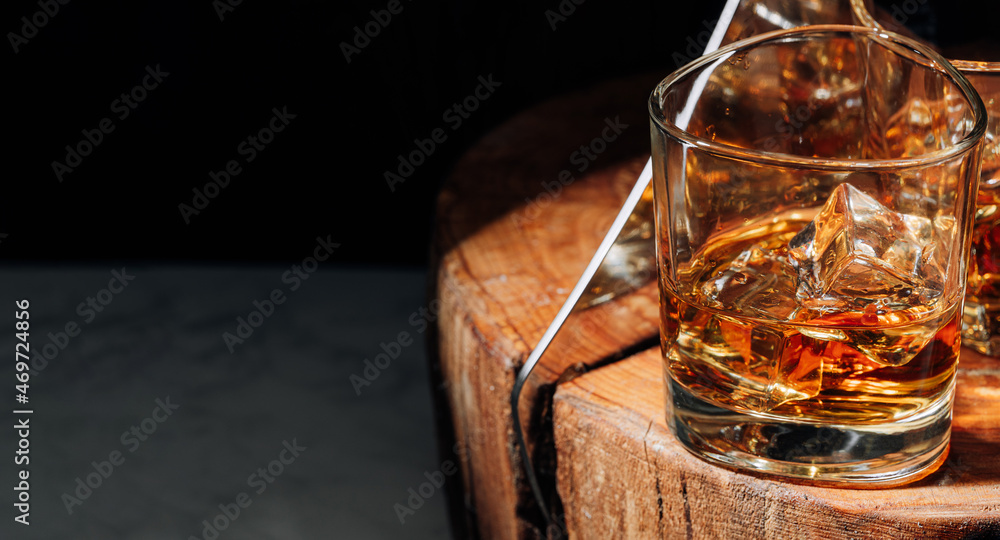 a cut of a tree, cut with a hatchet, there are two glasses of whiskey and ice on it. rest concept after a hard day at work. whiskey and wood a cut of a tree, cut with a hatchet, there are two glasses of whiskey and ice on it. rest concept after a hard day at work. whiskey and wood