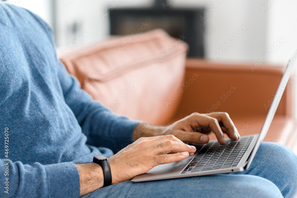 Fototapeta premium Close up image of male hands typing text on the laptop keyboard, working, responding to client e-mail, buying ordering items online. Electronics and modern wireless technology concept
