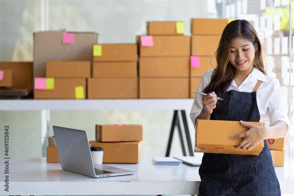 A young pretty woman who owns a small online business startup is smiling happily. A young pretty woman who owns a small online business startup is smiling happily.