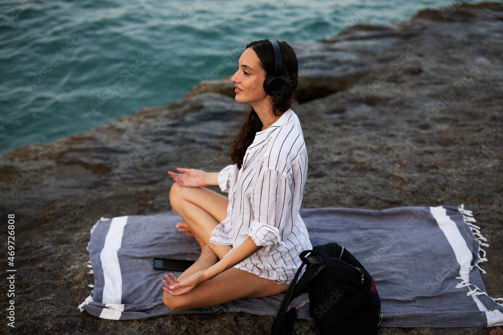 Hot woman relaxing on the sandy beach. Beautiful woman with headphones listening the music.. Hot woman relaxing on the sandy beach. Beautiful woman with headphones listening the music..