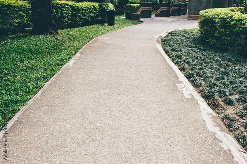 Cement trail with green spaces in the park