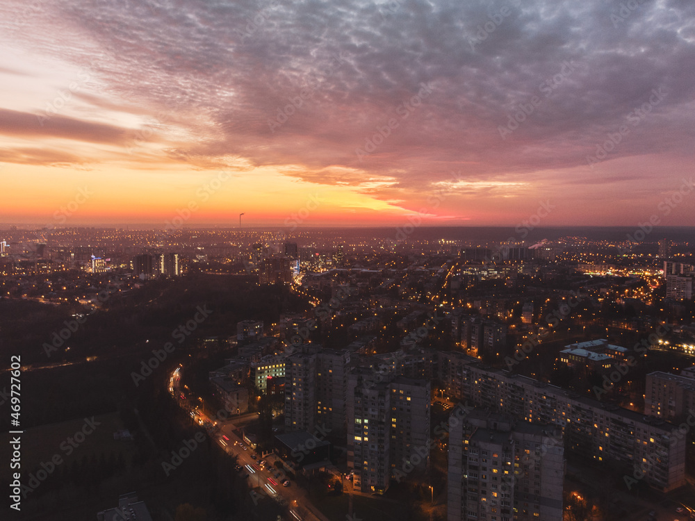 Aerial vivid colorful sunset view with epic skyscape. Kharkiv city center, Pavlove pole, botanical garden. Residential district illuminated streets and buildings in evening light