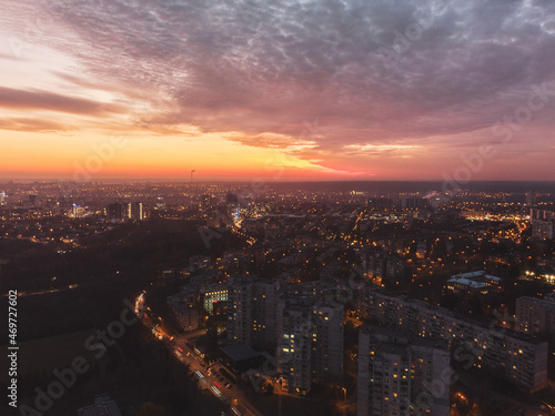 Aerial vivid colorful sunset view with epic skyscape. Kharkiv city center, Pavlove pole, botanical garden. Residential district illuminated streets and buildings in evening light