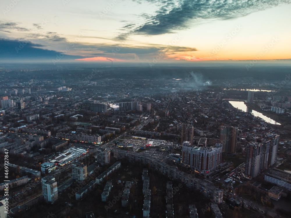 Aerial sunset evening view on residential Kharkiv city Pavlove Pole district. Gray multistory buildings with scenic cloudy sky on horizon