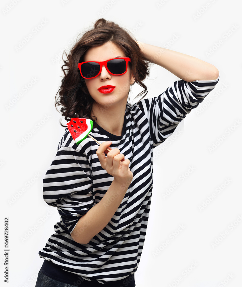 Fototapeta premium Portrait of happy girl , laughing at camera.Laughing girl holding big lollipop.Blue background.