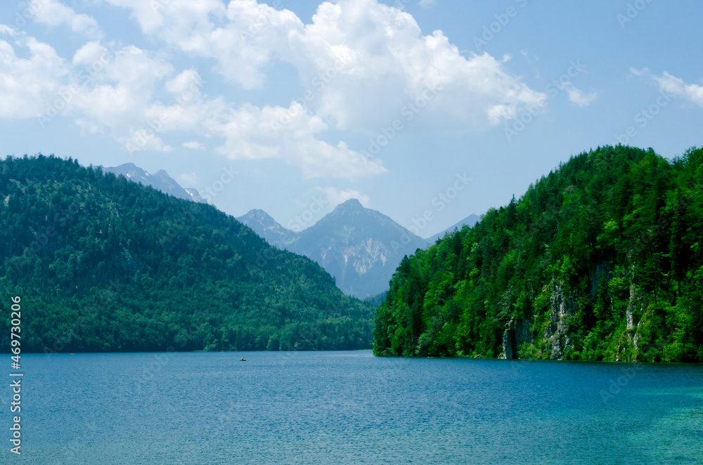 Alpsee lake landscape with Alps mountains near Munich in Bavaria, Germany. Crystal clear mountain lake and rocky mountains