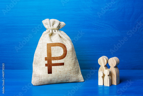 Family figurines and russian ruble money bag. Family budget. Investment in human capital. Income, expenses. Medicine and demography. Refugees crisis. Favorable conditions for population growth. photo