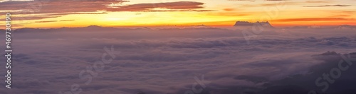 Heaven at early sunrise predawn clear sky with orange horizon and red atmosphere over the mountains with the morning mist. Panorama © AungMyo