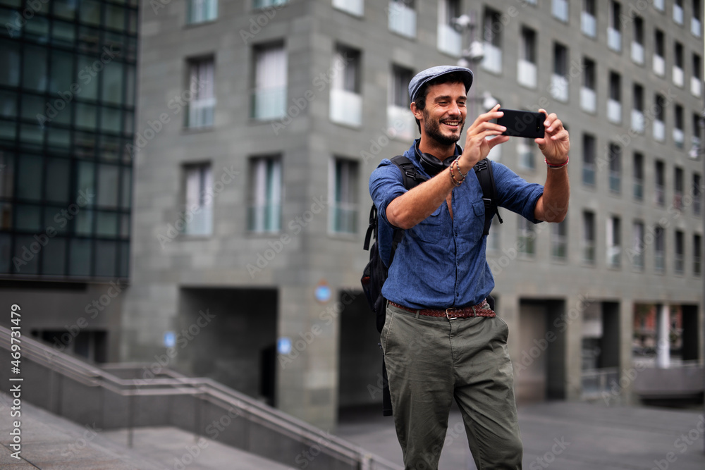 Young stylish man using the phone outdoors. Fashion happy guy enjoy outdoors... Young stylish man using the phone outdoors. Fashion happy guy enjoy outdoors...
