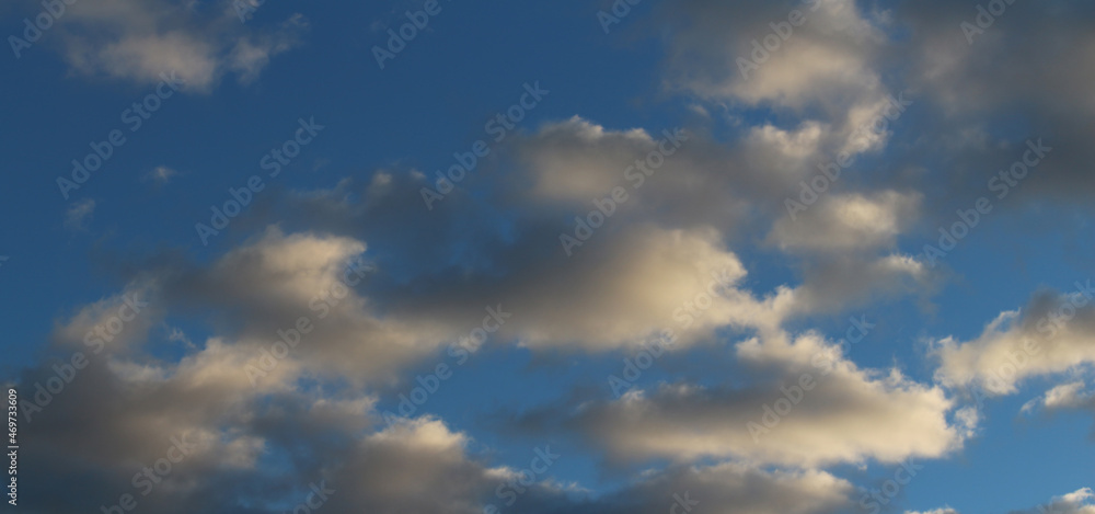 Blue morning sky with clouds illuminated by the sun - cloudscape background
