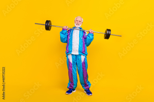 Full length photo of retired grandfather retro costume intense trainee barbell isolated over yellow color background