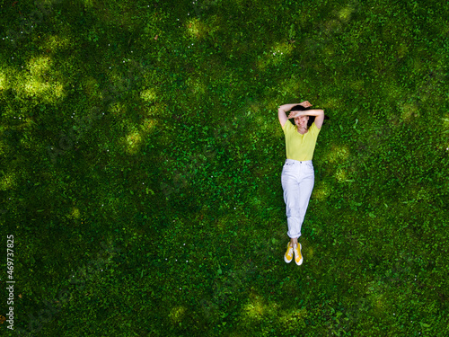 overhead view of woman laying down on green grass