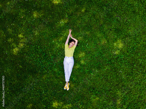 overhead view of woman laying down on green grass