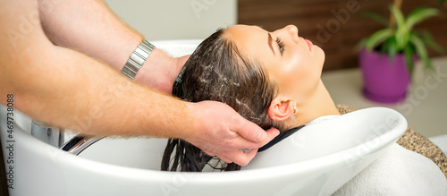 Beautiful caucasian woman washing hair in a beauty salon