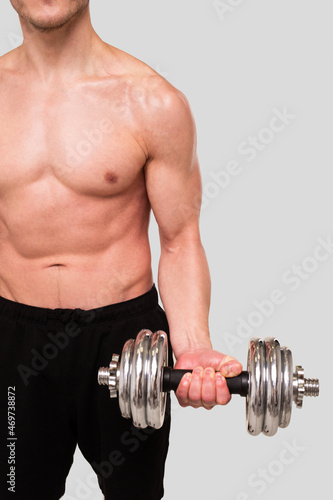 Man Topless Pumping Biceps with Dumbbell. Sprotsman Doing Training on Biceps Muscles. Gym, Lifting Sport Concept. Close Up