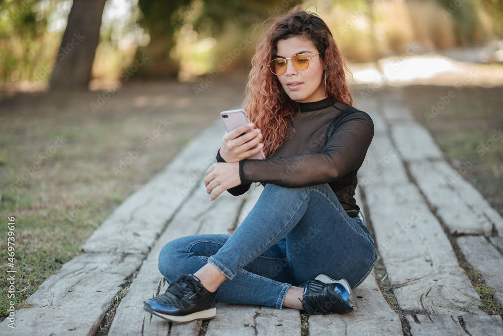 latin woman with glasses look at your mobile phone outdoors latin woman with glasses look at your mobile phone outdoors