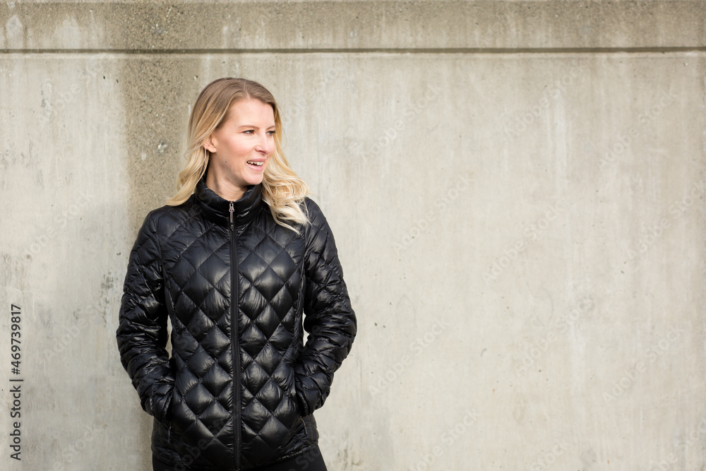 Smiling portrait of pretty blonde woman in quilted jacket Smiling portrait of pretty blonde woman in quilted jacket
