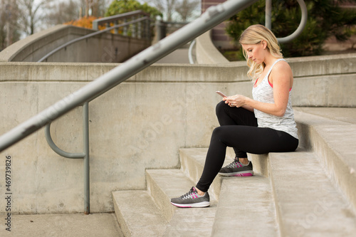 Attrractive woman in workout gear texting photo