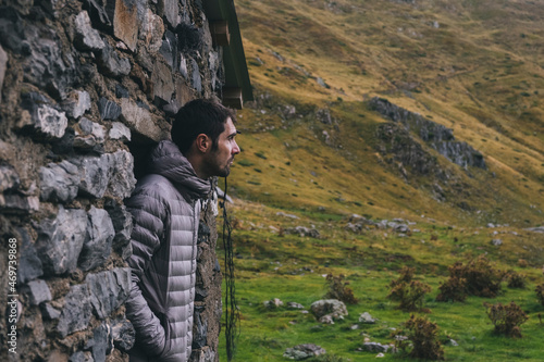 Man just outside mountain hut looking at the weather. Pyrenees. photo